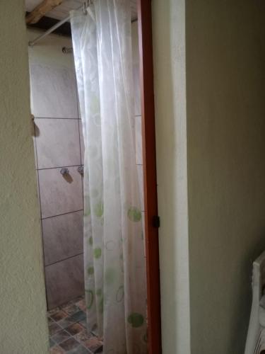 a shower with a white shower curtain in a bathroom at EL ENCUENTRO Domo Geodesico in Miramar