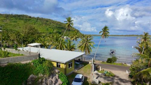 a yellow house on the shore of a body of water at O'Hani-Ura lodge in Bora Bora