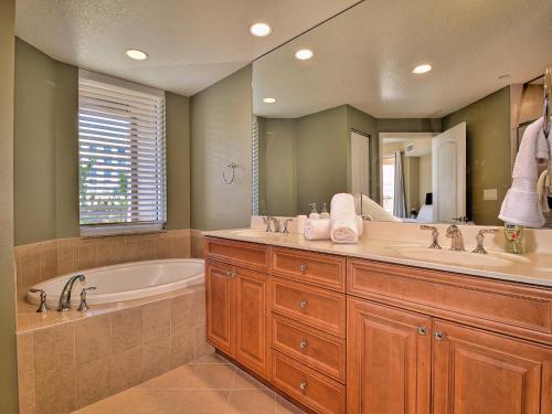 a bathroom with two sinks and a tub and a large mirror at Belle Harbor 401W in Clearwater Beach