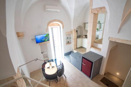 an attic living room with a table and a window at Nivèra White Allure Maison in Ostuni