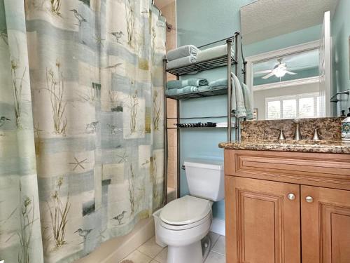 a bathroom with a toilet and a shower curtain at Chateaus on White Sands 302 in Clearwater Beach