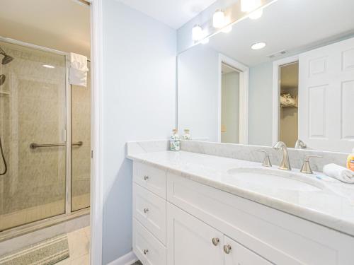 een witte badkamer met een wastafel en een douche bij Sonrisa 11 in Clearwater Beach