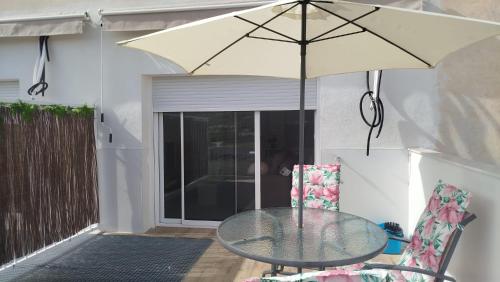 a table with an umbrella on a patio at Alojamientos, Rafael muñoz in Alcaudete