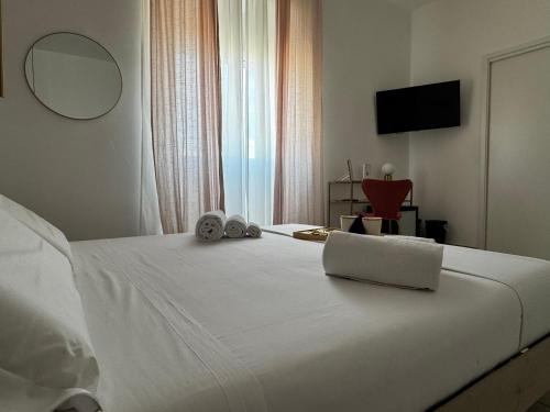 a bedroom with a white bed with a laptop on it at Serèsia Rooms Siracusa Centro in Syracuse