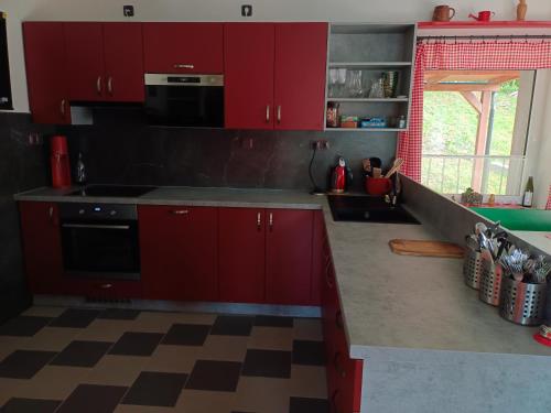 a kitchen with red cabinets and a stove top oven at Parádní chalupa in Semily