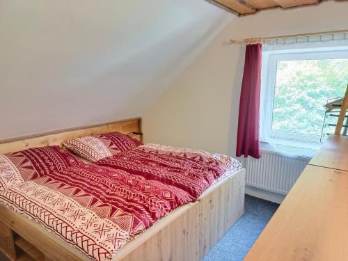 a bed in a room with a window at Parádní chalupa in Semily