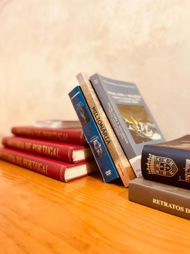 a pile of books sitting on top of a table at Oi Braga Hostel in Braga