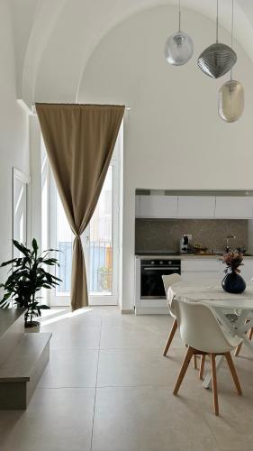 a white kitchen with a table and chairs and a window at Nina Mia in Fasano
