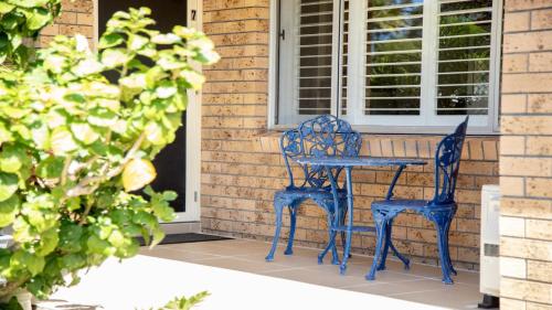 a blue table and two chairs on a porch at Oceanique in Old Bar