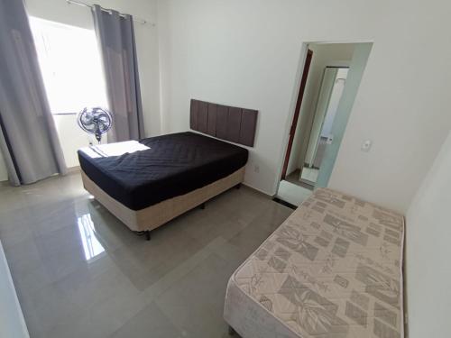 a small bedroom with a bed and a mirror at Casa Rua da Lagoa in Araruama