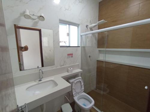 a bathroom with a sink and a toilet and a mirror at Casa Rua da Lagoa in Araruama