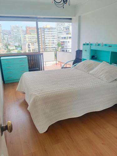 a bedroom with a large bed and a large window at Departamento Poniente a pasos del casino y playas in Viña del Mar