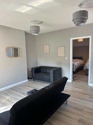 a living room with a couch and a bed at Stadium Apart - Free Parking & WiFi in Crewe