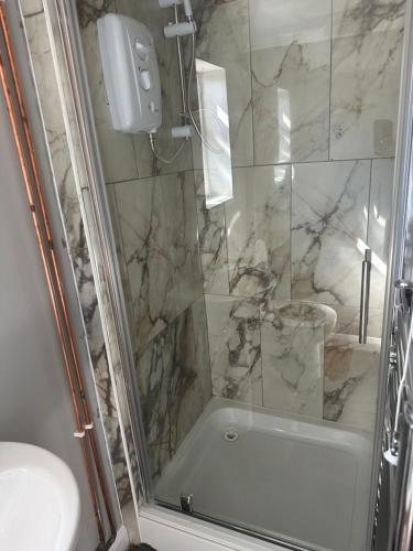 a bathroom with a shower with a sink and a toilet at Stadium Apart - Free Parking & WiFi in Crewe