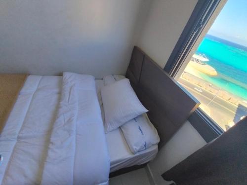 a bed in a room with a view of the beach at Luxury units for rent on the sea in Marsa Matruh