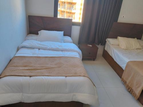 a hotel room with two beds and a window at Luxury units for rent on the sea in Marsa Matruh