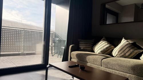 a living room with a couch and a view of a balcony at Svarog Unique Apartment by CHORS in Bratislava