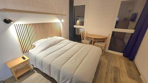 ジョンザックにあるStudio Cosy 1persの白いベッドとテーブルと椅子のある寝室