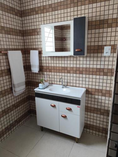 a bathroom with a white sink and a mirror at Apto Dom Pedrito in Dom Pedrito
