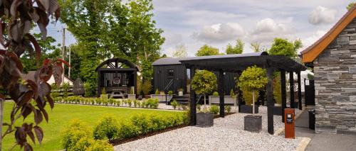 a garden with a black building in the background at Cherry Tree Lodge in Limavady