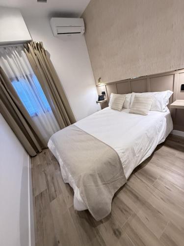 a bedroom with a white bed and a window at Be RELAX TORREJON in Torrejón de Ardoz