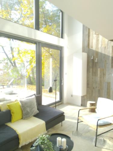a living room with a couch and a large window at Leśny Domek - Świekatowo in Świekatowo