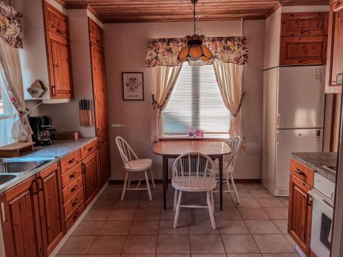 ビンメルビューにあるDaisy's Home Vimmerbyのテーブルと椅子と窓のあるキッチン