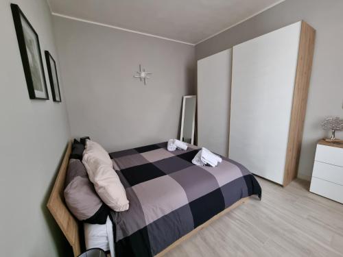 een slaapkamer met een bed met een geruite deken bij Cà Fiamma 1 in Casale Monferrato