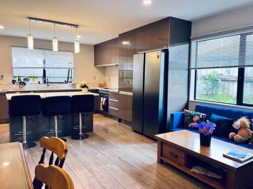 a kitchen with a blue couch and a table at Modern Sunny & Comfy Rooms with Ultra-Fast Fibre & Free Parking in Auckland in Auckland