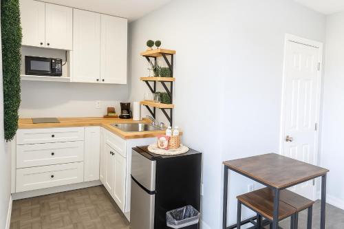 a kitchen with white cabinets and a sink and a table at Cozy with Private Entry Near Fort Myers & Airport in Lehigh Acres