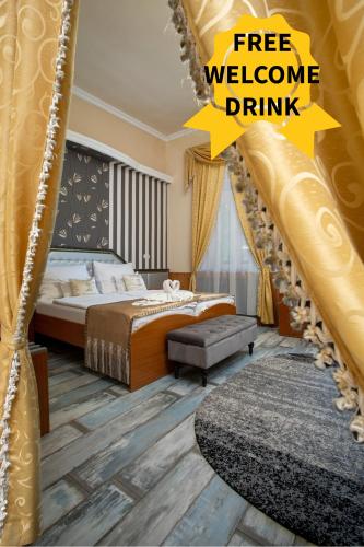 a bedroom with a bed and a yellow sign that reads free welcome drink at Illés Hotel in Szeged