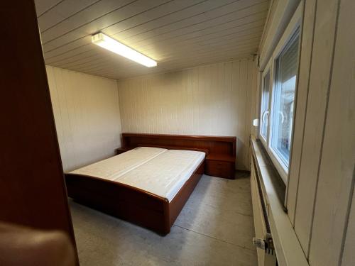 a small bedroom with a bed and a window at TL Gastzimmer in Frankfurt/Main