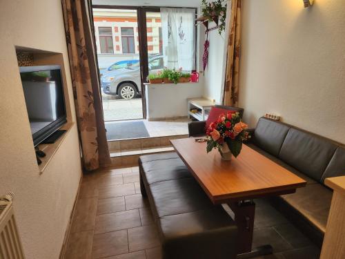a living room with a couch and a table and a television at Halle, TOP -PREISE, große 79 qm SD FeWo, EG, wahlweise mit 1- 3 DZ, inklusiv TV Lounge, Küche, Bad WC Einfach und gut, Langzeitmieter VB Preise in Halle an der Saale