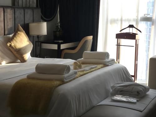 a hotel room with two beds with towels on them at Deluxe Marina View 2BR - Stella Maris Retreat in Dubai