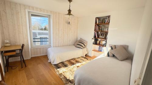 a bedroom with two beds and a window at La Vigie - Maison en bord de mer in Lion-sur-Mer