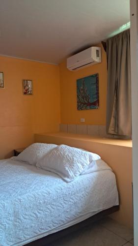 a bedroom with a white bed with a window at Apartamento La Fortuna #2 in Fortuna