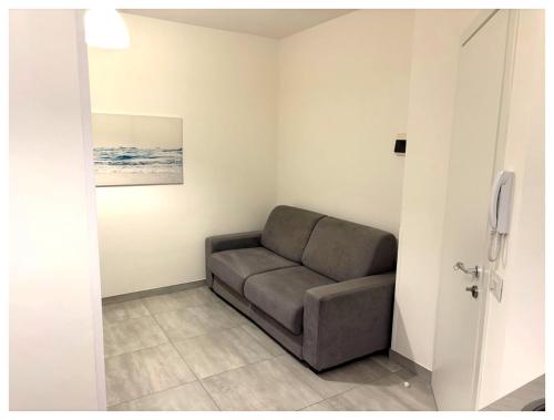a couch sitting in a corner of a room at Teti Suite Rooms in Pozzallo