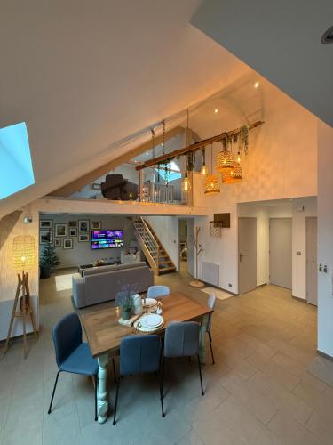 a dining room and living room with a table and chairs at Au café de Jeanne - Entrelacs in Pouilly