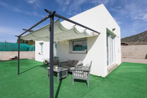 a patio with a white canopy on a green lawn at EyA House in Padul