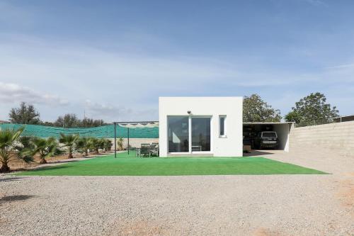 a small white house with a green lawn at EyA House in Padul