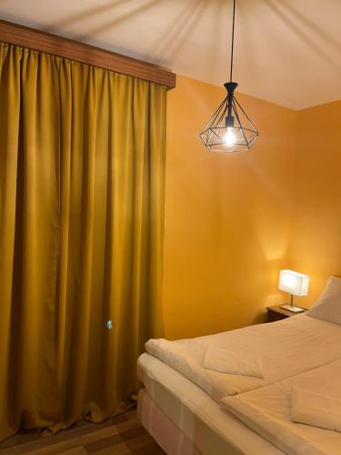 una camera con due letti e una tenda verde di Boulevard Serenity Apartment a Miercurea-Ciuc