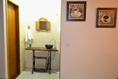 a bathroom with a small table and a sink at Seu lugar na Mantiqueira é aqui! Seja bem-vindo! in Itanhandu