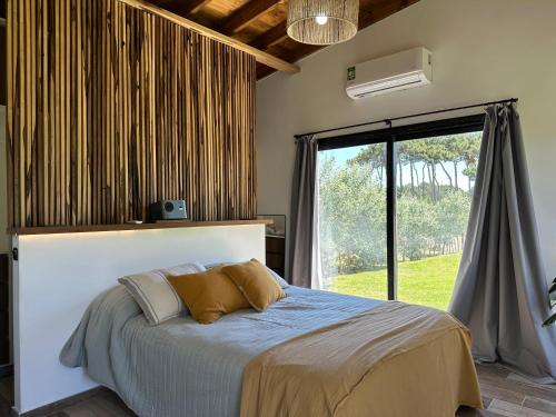 une chambre avec un lit et une grande fenêtre dans l'établissement Casa Moderna, Barrio Nayades, à Pinamar