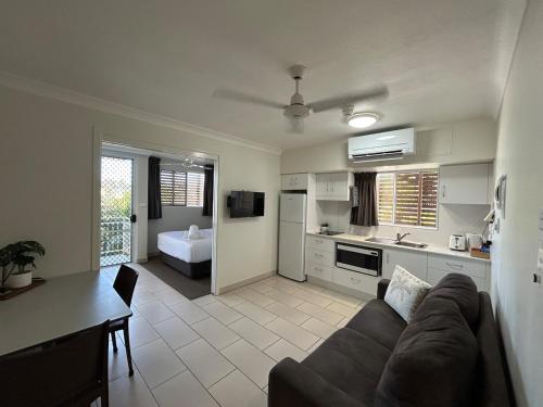 a living room with a couch and a kitchen at Luxury Coastal Escape at Endeavor Inn - Emu Park in Emu Park