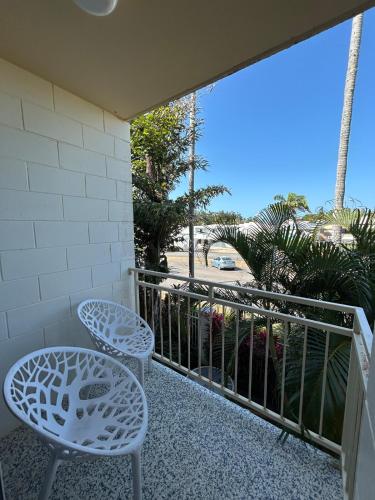 two chairs and a table on a balcony at Luxury Coastal Escape at Endeavor Inn - Emu Park in Emu Park