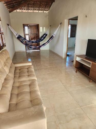 a living room with a couch and a hammock at Casa por do sol Flecheiras in Flecheiras