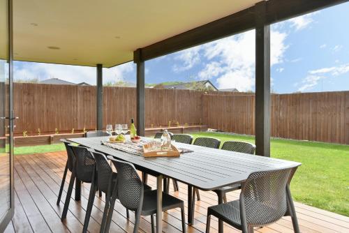 uma mesa de jantar e cadeiras em um deck com cerca em Spacious Family & Group Retreat - Wigram Residence em Christchurch