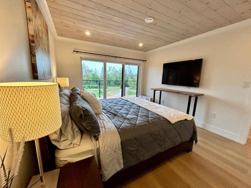 een slaapkamer met een bed en een groot raam bij Garagemahal on Glengyle in Milton Station