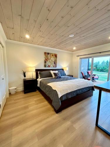 a bedroom with a large bed and a wooden floor at Garagemahal on Glengyle in Milton Station
