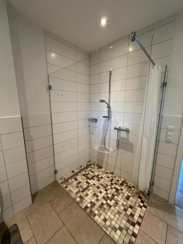 a bathroom with a shower with a tiled floor at Monteurswohnung 5P Lohne in Wietmarschen